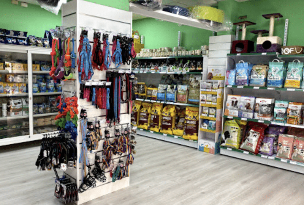 Estante con correas y accesorios para mascotas en una tienda de productos para animales.